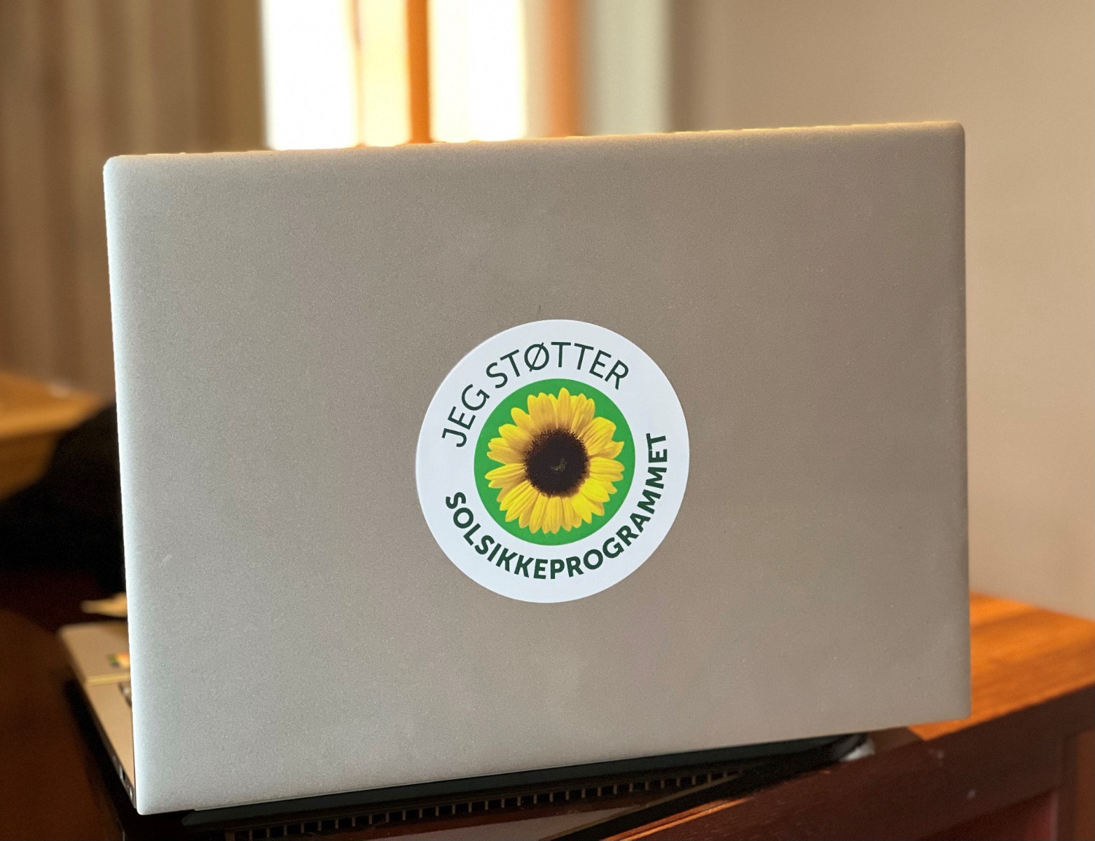 Jeg støtter solsikkeklistermærket på en sølvbærbar computer