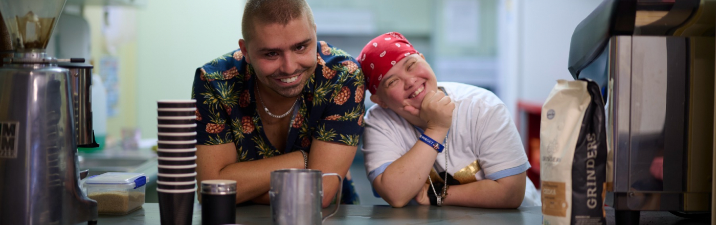 Two people smiling at a counter