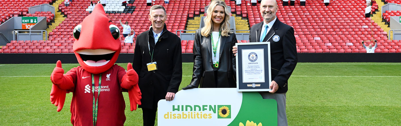 Group of people holding the world;s longestr lanyard certificate standing at Liverpool Football Club