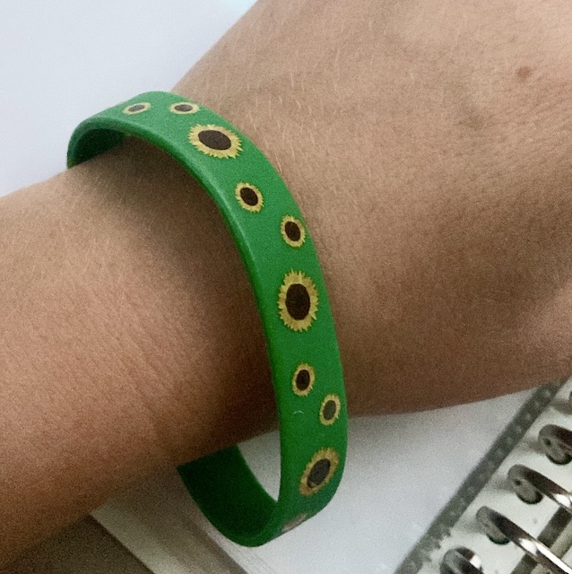 Photo of wrist with green Sunflower wristband