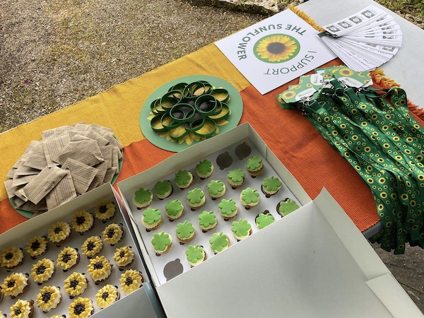 A Sunflower stand with packets of Sunflower seeds, Sunflower and shamrock cupcakes and hidden disabilities Sunflower wristbands and lanyards 