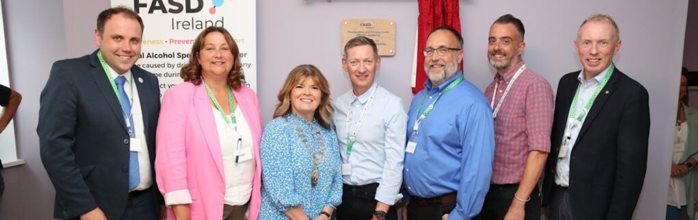 Member s of the Sunflower team meet with Irish members of state. There is an FASD Ireland poster in the background. Sunflower lanyards are worn by all