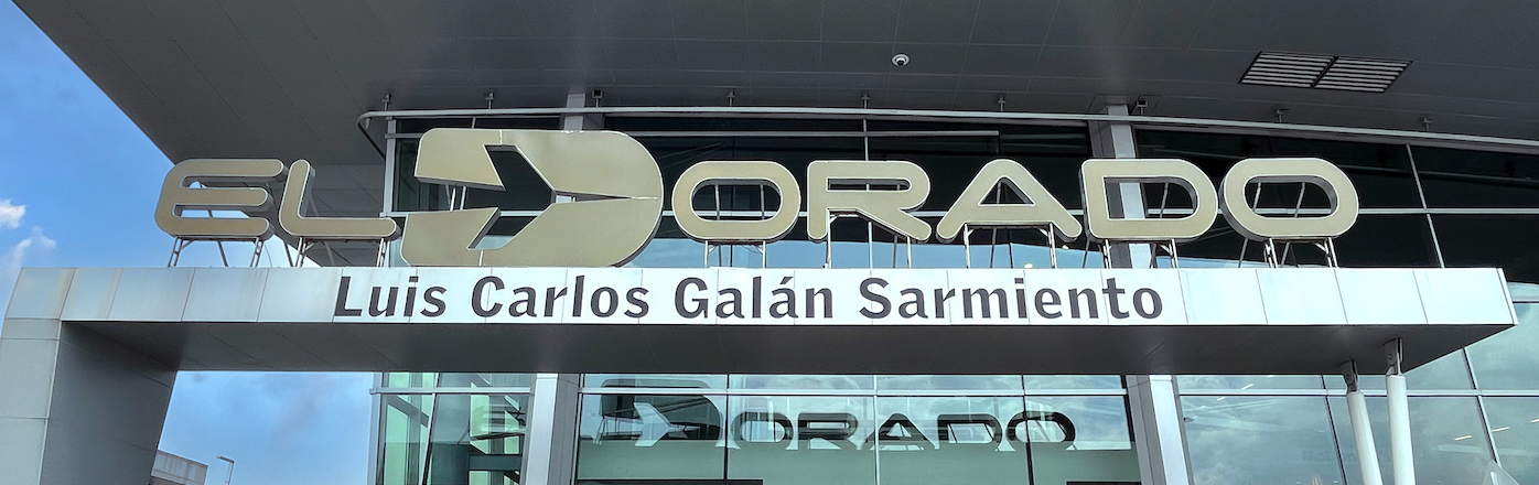 The glass entrance to El Dorado airport. The airports name is displayed above the door