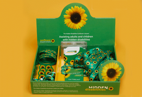 Green box with Sunflower design containing a selection of Hidden Disabilities Sunflower products